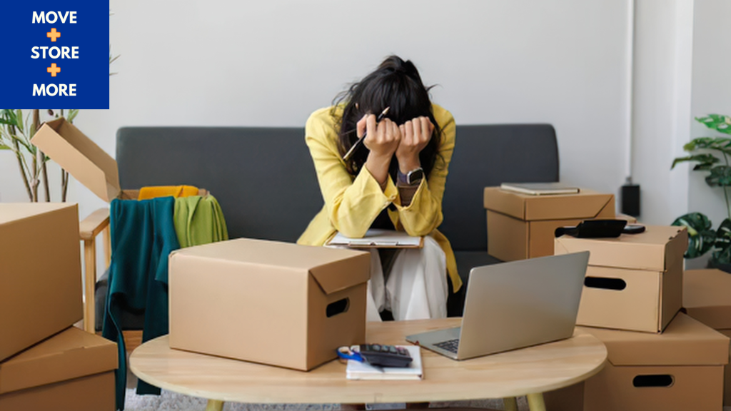 Image of stressed homeowner surrounded by half-packed boxes.